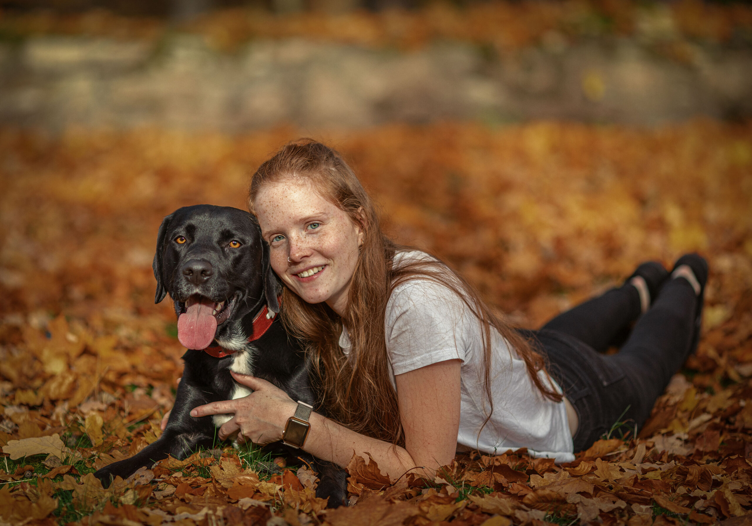 Rothaarige junge Frau liegt mit Hund im Herbstlaub,Hunde und Pferdefotografie im Erzgebirge, Hunde und Pferdeshooting im Erzgebirge. Emotionale Hundeportraits