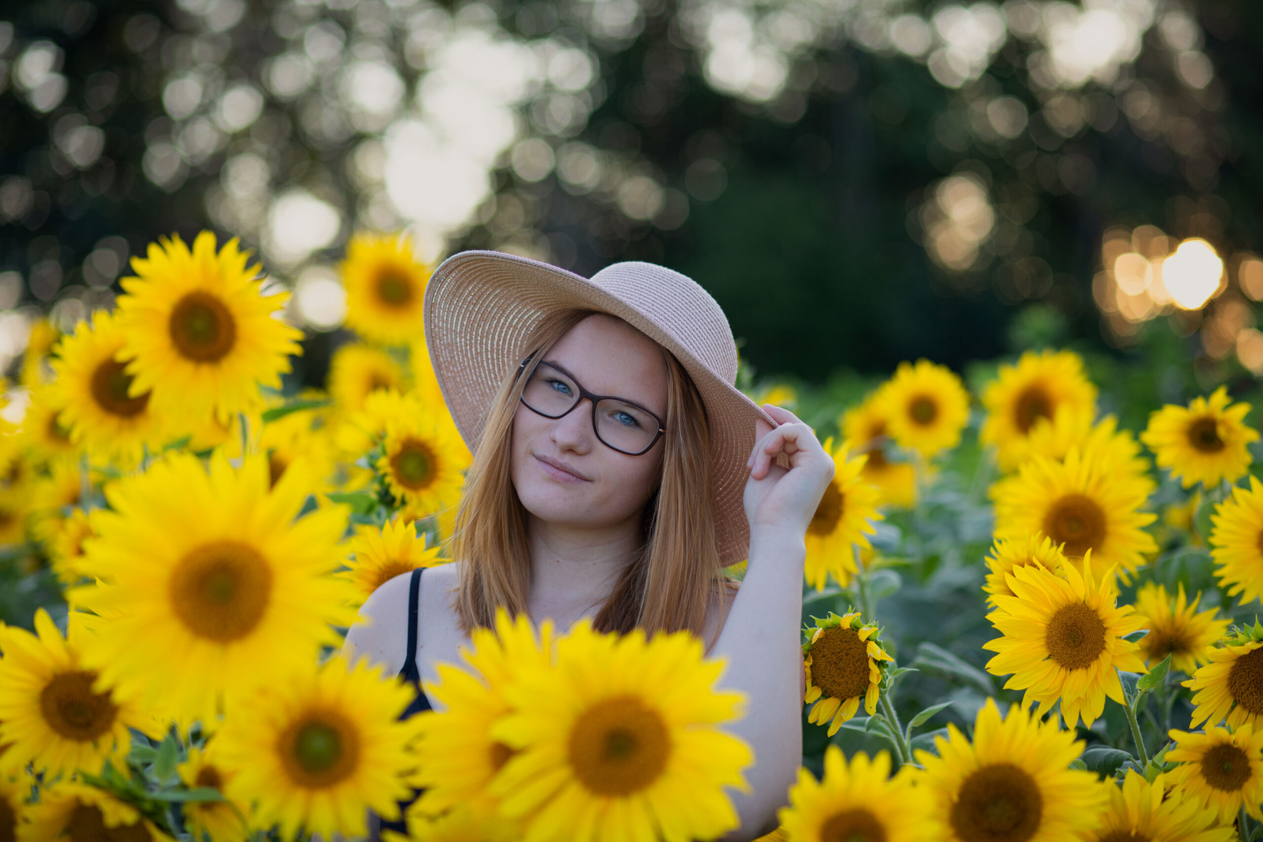 Junge Frau mit Sonnenhut im Sonnenblumenfeld, Portraitfotografie, Portraits im Erzgebirge, Fotoshooting Erzgebirge, Fotoshooting in Thermalbad-Wiesenbad, Portraitshooting Annaberg-Buchholz und Umgebung,Outdoorportrait