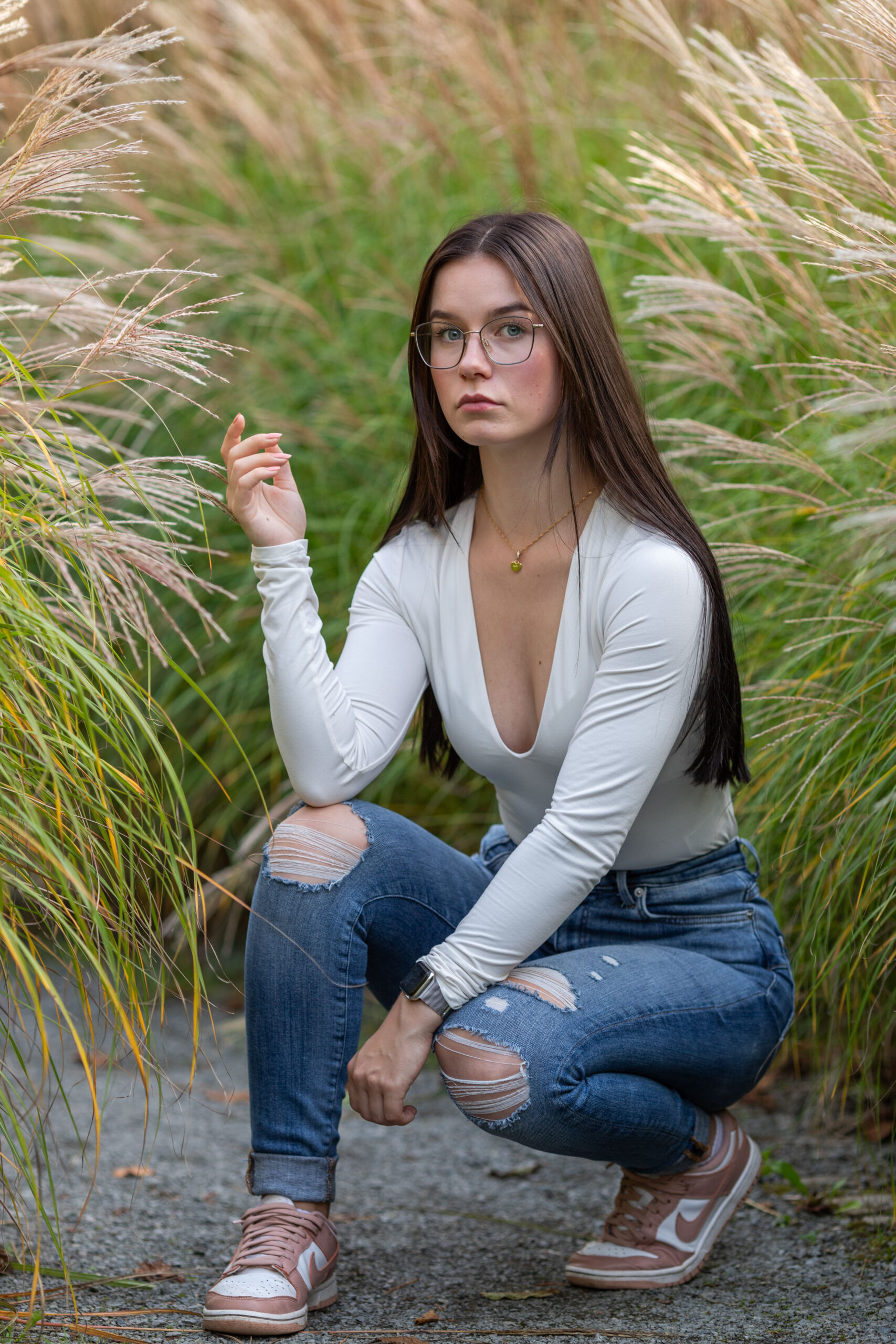 Junge Frau hockt zwischen Gräsern, Portraitfotografie, Portraitfotografie im Erzgebirge, Fotoshooting Erzgebirge, Fotoshooting in Thermalbad-Wiesenbad, Portraitshooting Annaberg-Buchholz und Umgebung