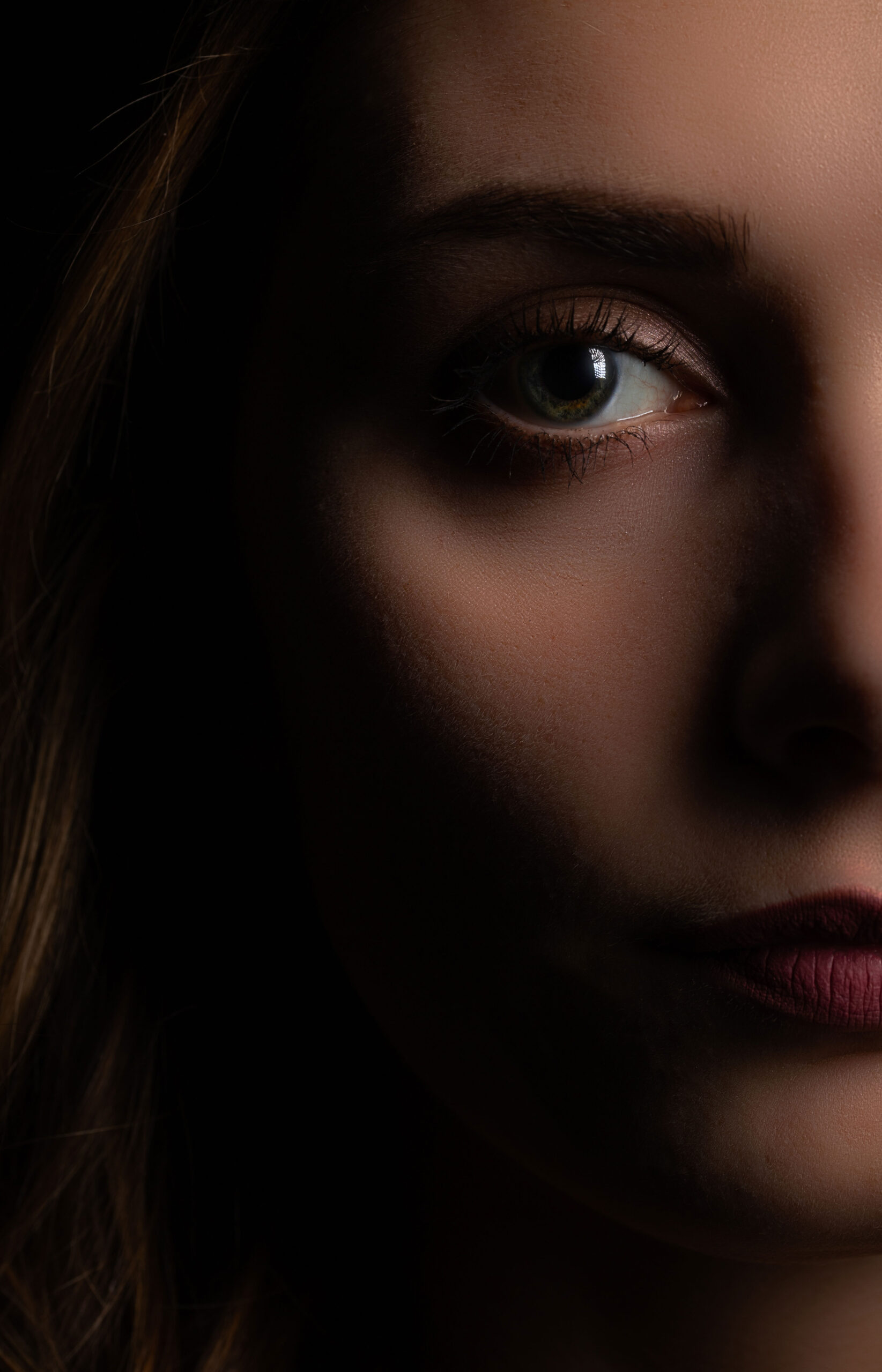 Halbgesichtsportrait einer jungen Frau mit Bitz und Softbox