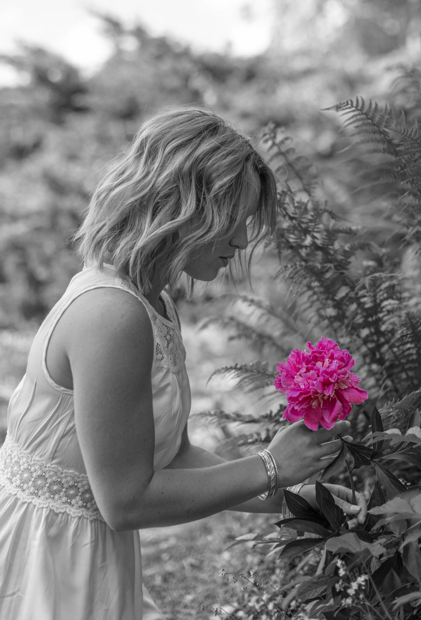 Porträt einer jungen Frau mit einer Pfingstrose in der Hand