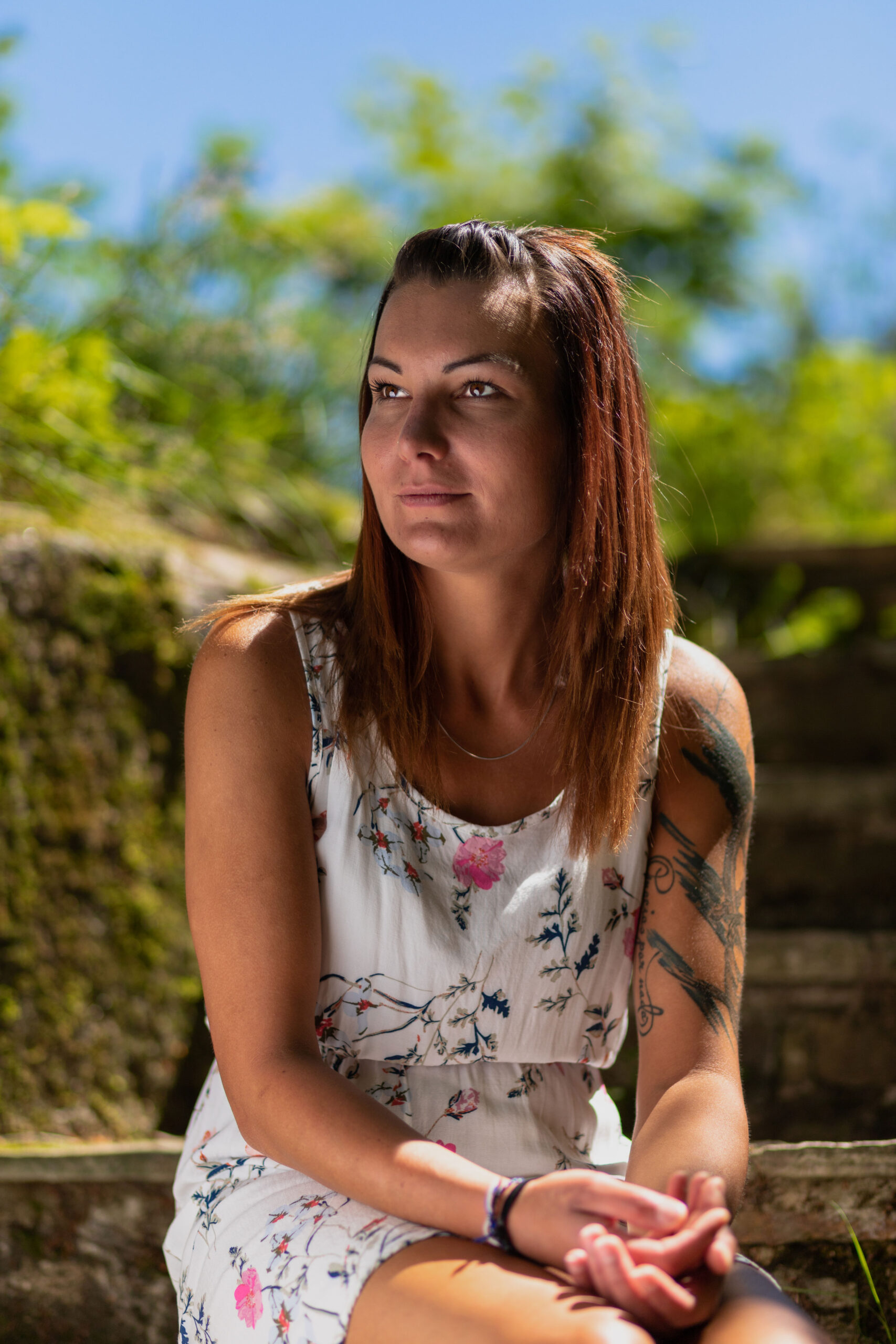 Porträt einer jungen Frau die auf einer alten Steintreppe sitzt