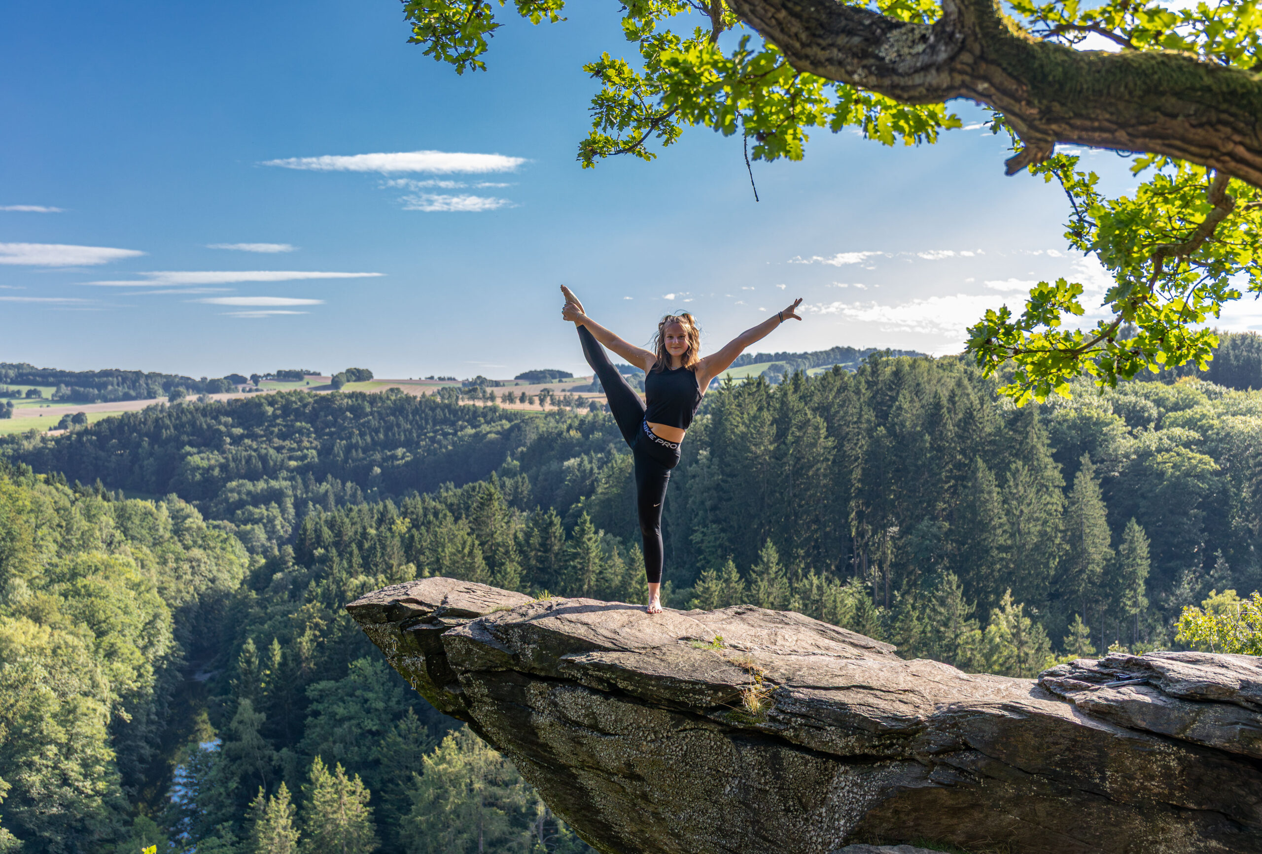 Turnerin posiert mit Übung auf der Brückenklippe in der Wolkensteiner Schweiz