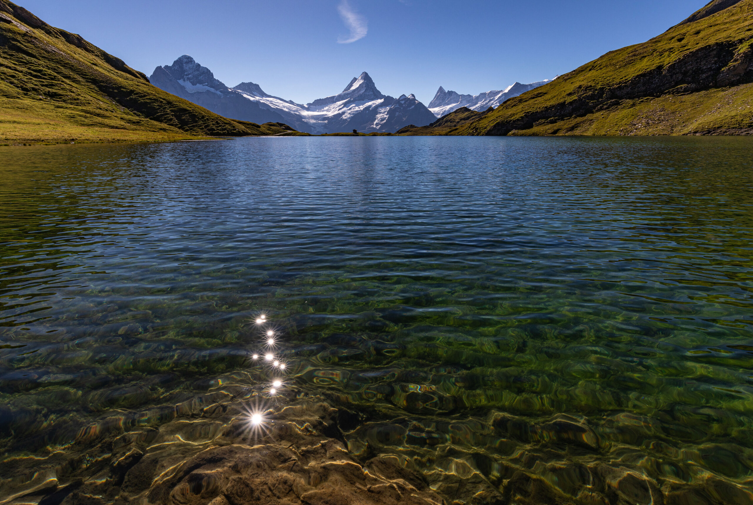 Im klaren Wasser des Bachalpsees spiegelt sich die Sonne