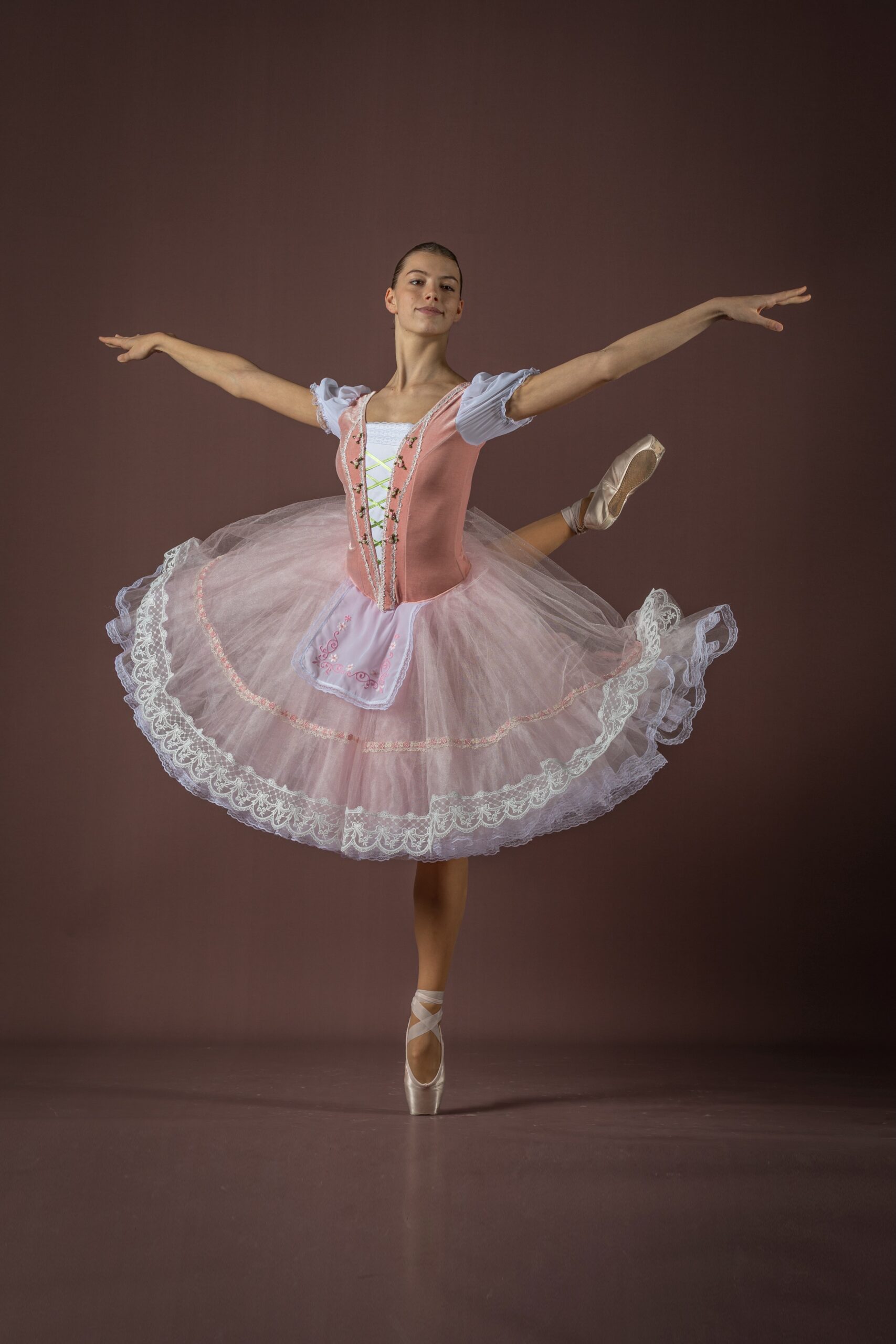 Ballerina in festlichem Ballettkleid steht auf Spitze