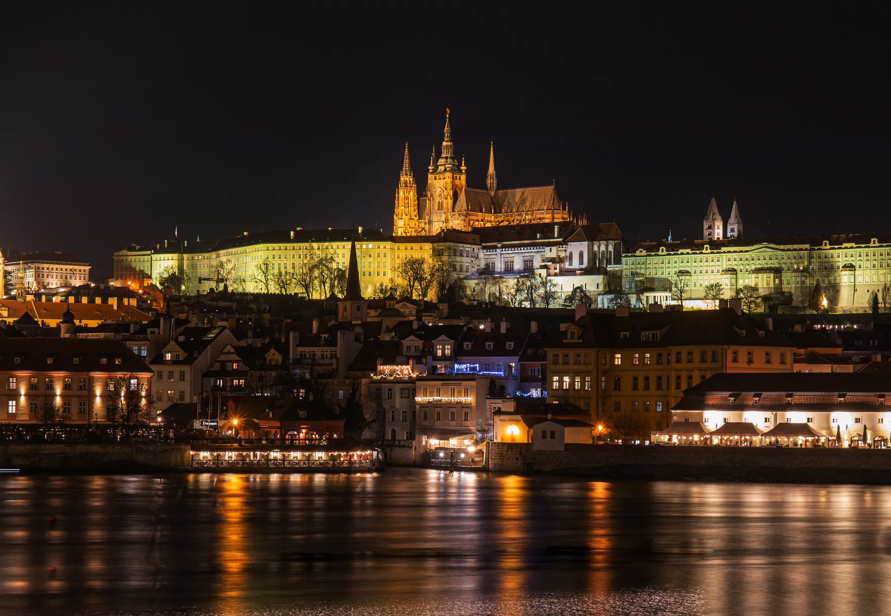 Landschaftsfotografie einer nächtlichen Stadtansicht von Prag welches die Prager Burg beleuchtet zeigt.