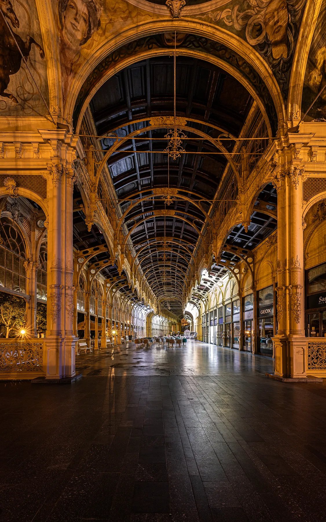 Die Kolonnaden von Marienbad zeichnen sich durch hohe Gewölbedecken, Säulen, Goldakzente, Wandmalereien und elegante architektonische Details aus. Nachts ist diese verzierte Halle warm beleuchtet und bietet mit ihren Geschäften und Schaufenstern entlang einer Seite eine großartige Atmosphäre.
