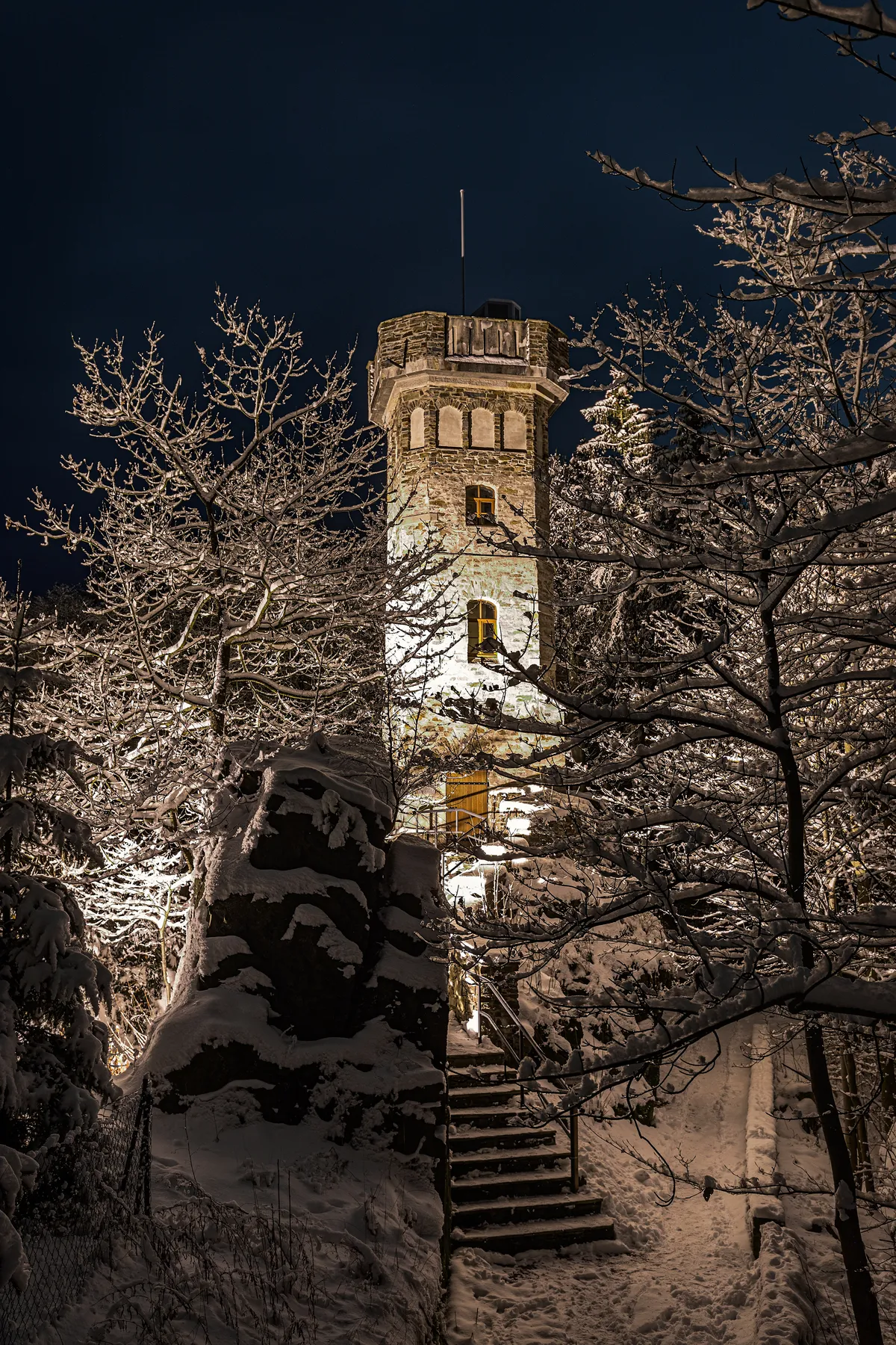 Beleuchteter Bismarckturm im verschneiten Wald bei Nacht in Thermalbad-Wiesenbad