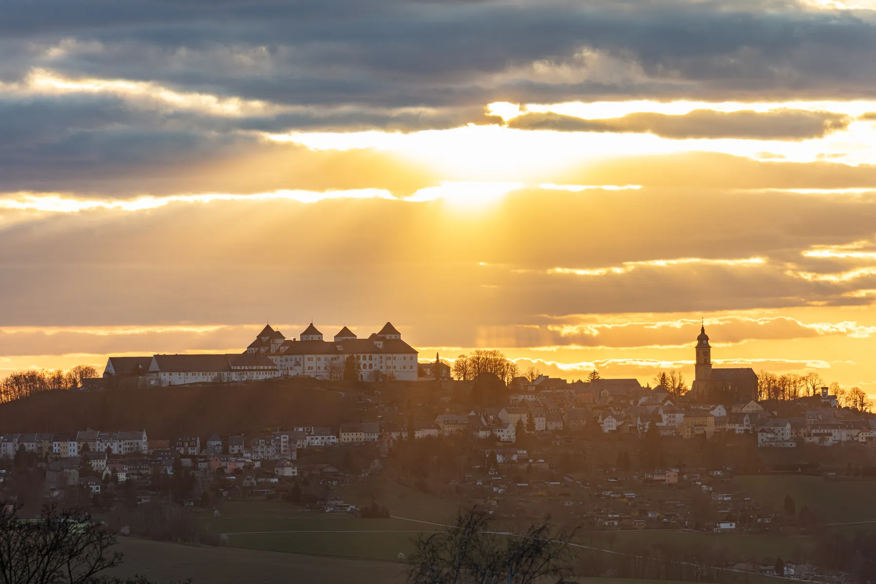 Sonnenuntergang über einer Stadtlandschaft mit Schloss Augustusburg im Erzgebirge