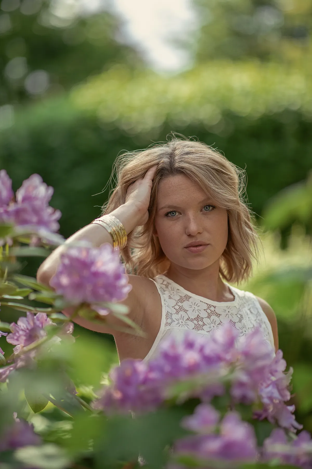 Portraitfotografie einer jungen Frau in natürlichem Licht und lila Blumen