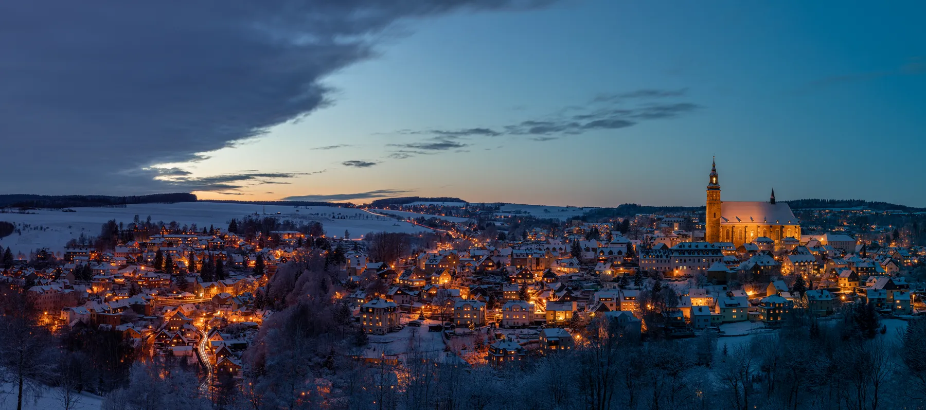Bergstadt Schneeberg mit beleuchteter Kirche in der blauen Stunde im Erzgebirge
