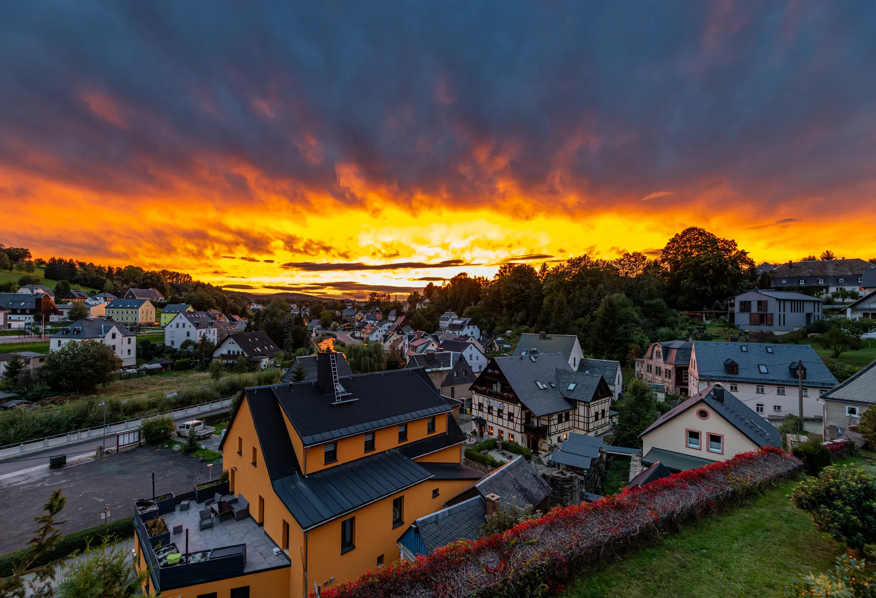Dorfansicht von Wiesa im Erzgebirge mit farbigem Sonnenuntergang und leuchtenden Wolken über den Häusern