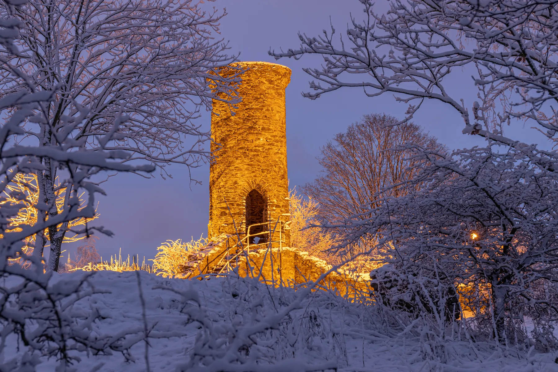 Schreckenbergruine bei Annaberg-Buchholz, beleuchteter Burgturm im Winter in der Dämmerung