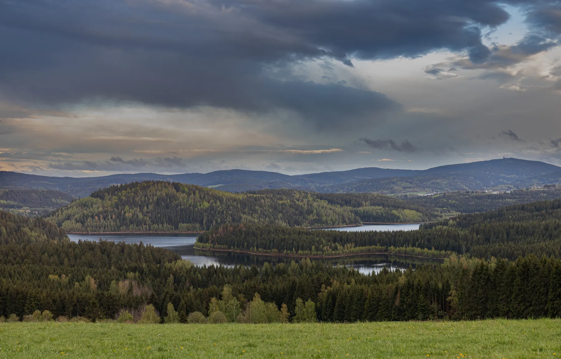 Weite Erzgebirgslandschaft mit Talsperre Eibenstock vom Hundshübel gesehen, mit bewaldeten Hügeln und wechselhaftem Himmel