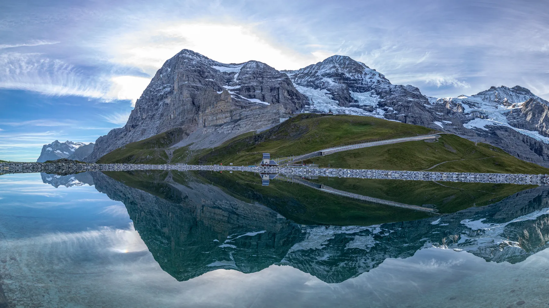 Landschaftsfotografie des Eigers, Mönch und der Jungfrau welche sich in einem künstlichen See spiegeln.