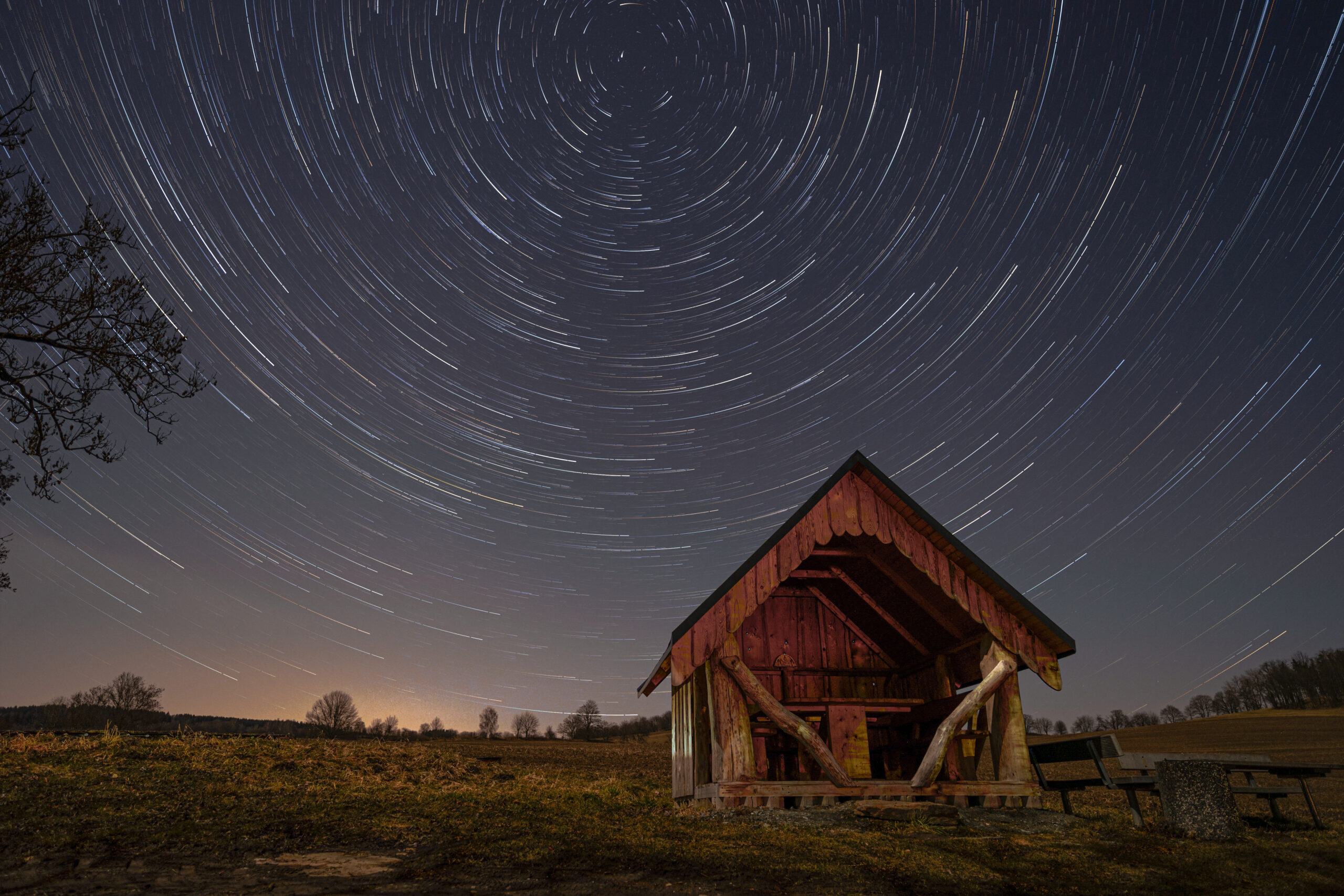 Wanderhütte über der im Kreis sogenannte Startrails zu sehen sind