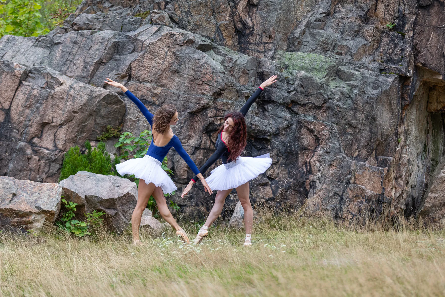 Zwei Ballerinas im weißen Tutu vor einer markanten Felswand in der Binge Geyer