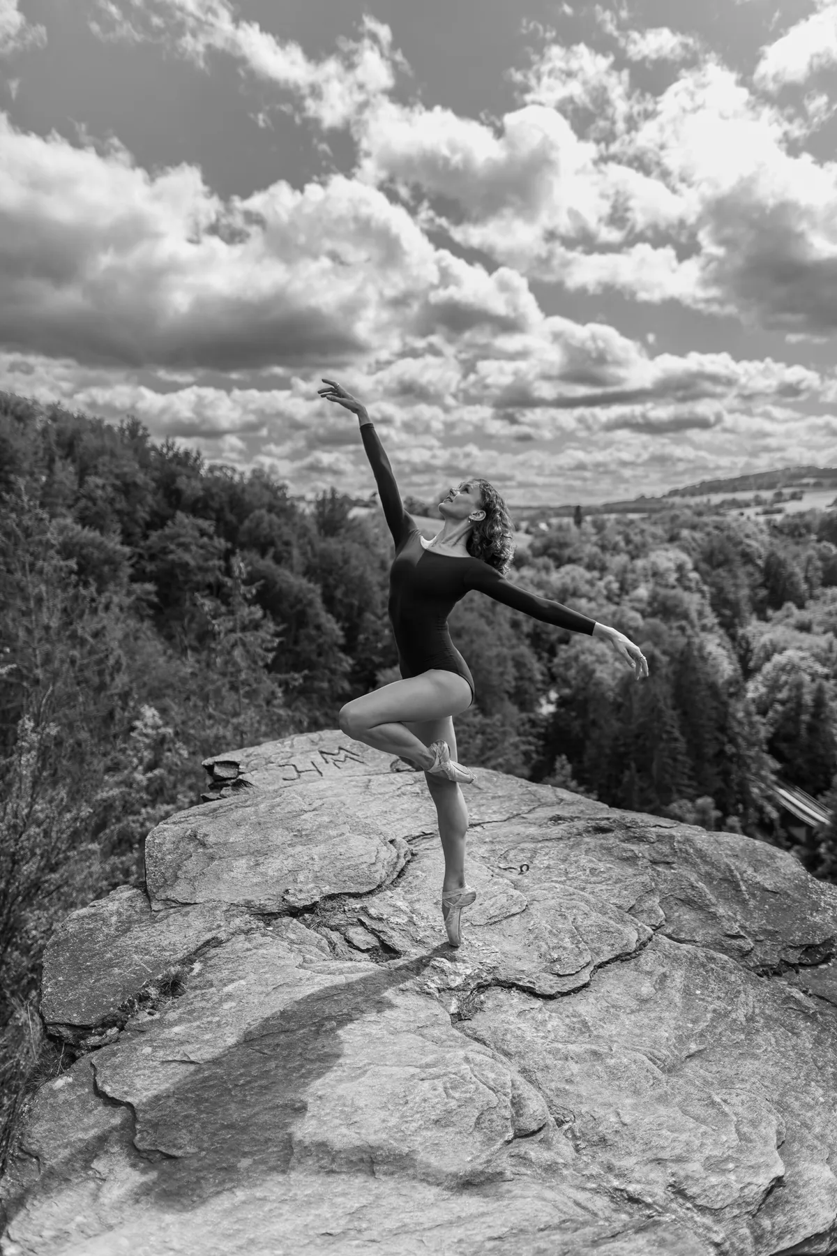 Ballerina auf Spitze auf einem Felsen vor der Waldlandschaft des Erzgebirges